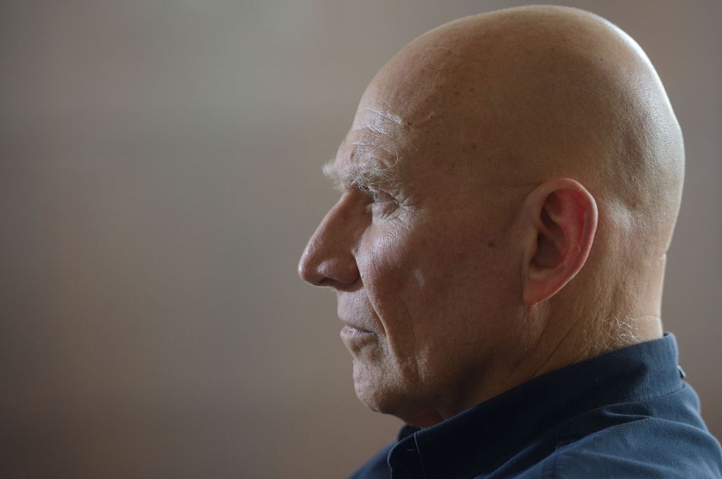 Retrato de Sebastião Salgado, de perfil, con fondo neutro