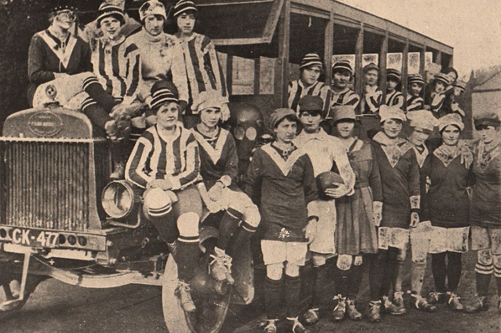 Jugadoras del equipo Dick, Kerr Ladies posan con su uniforme junto a un autobús, década de 1920