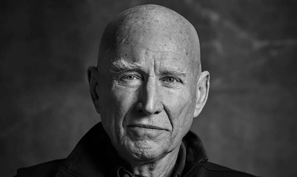 Retrato de Sebastião Salgado, de perfil, con fondo neutro