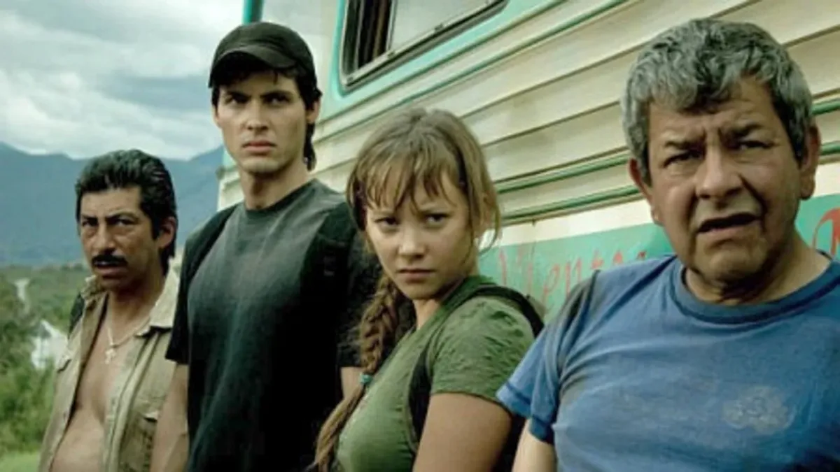 Cuatro personajes principales de la película Paraíso Travel junto a un vehículo, con expresión seria.
