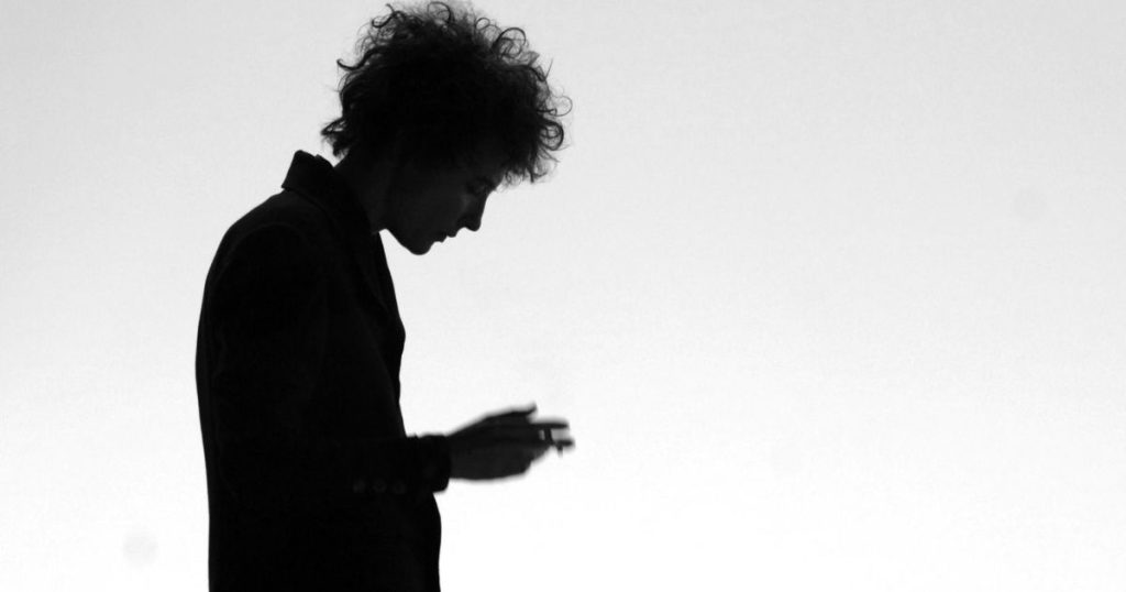 Silueta en blanco y negro de una figura andrógina de rock fumando, fotograma de la película 'No estoy allí'