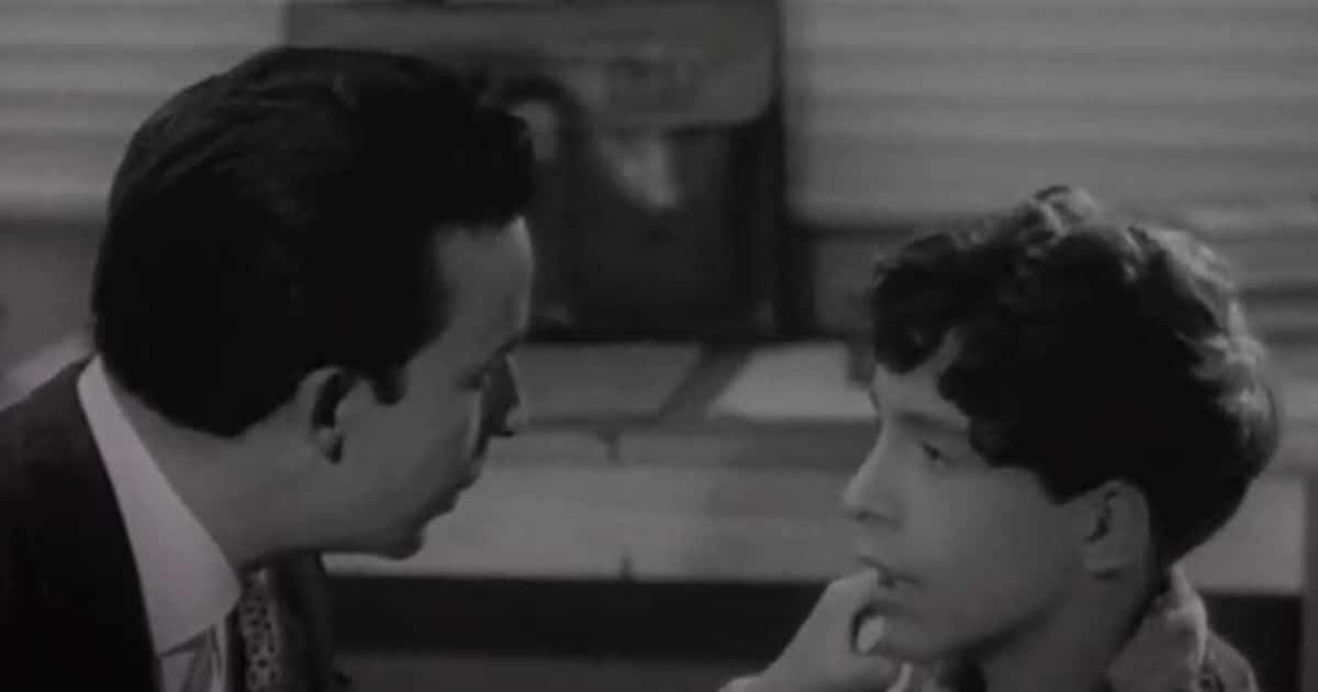 Un hombre y un niño conversan en una escena en blanco y negro de La frontera del sueño
