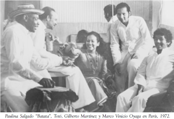 Fotografía en blanco y negro de Totó la Momposina sentada junto a varios músicos colombianos en París durante 1972, en un ambiente informal y de conversación.
