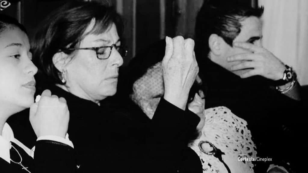 Familia de Mariano Concha durante un funeral en La pena máxima, con varios personajes sentados y vestidos de negro en una escena de duelo doméstico.