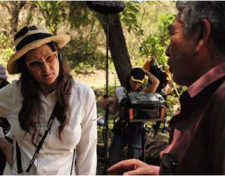 Lucrecia Martel conversa con un hombre durante el rodaje de Nuestra tierra, en un entorno rural.