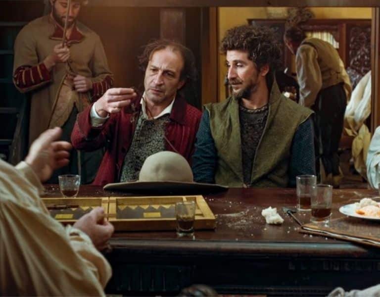 Escena de Zama, de Lucrecia Martel, con varios hombres vestidos con trajes de época alrededor de una mesa.