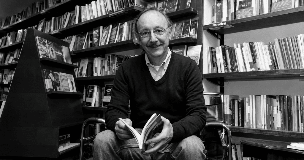 Mauricio Lleras, creador de la librería Prólogo, sentado entre estantes de libros en Bogotá.