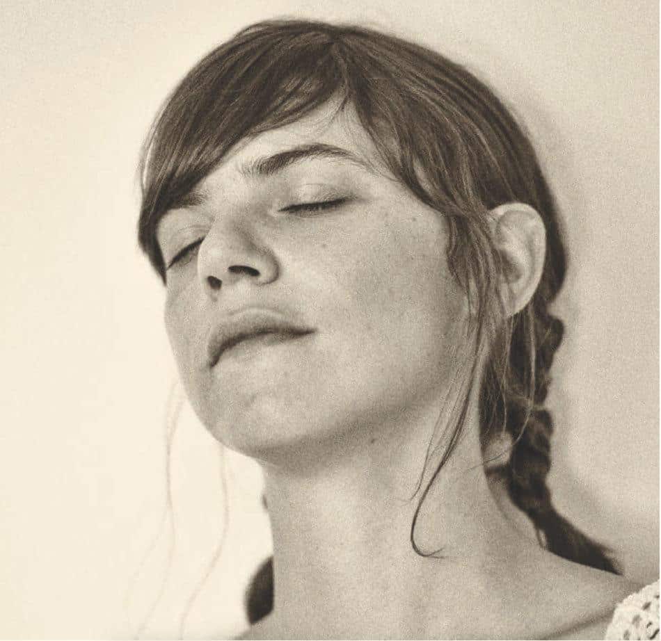 Retrato en sepia de Valeria Luiselli, con los ojos cerrados y el pelo recogido en una trenza
