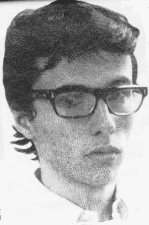 Retrato en blanco y negro de Andrés Caicedo joven, con gafas de pasta oscura y el pelo corto